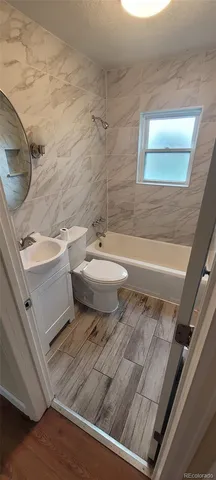 a bathroom with a granite countertop toilet a sink and a mirror