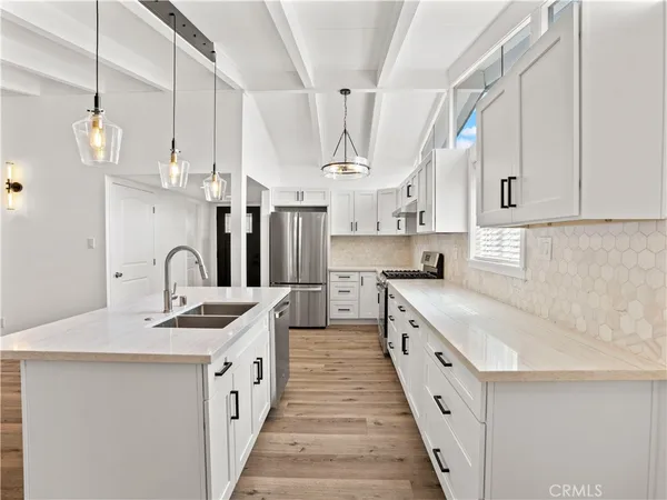 a kitchen with kitchen island white cabinets sink and white appliances