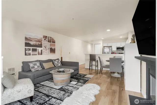 a living room with furniture a flat screen tv and a table