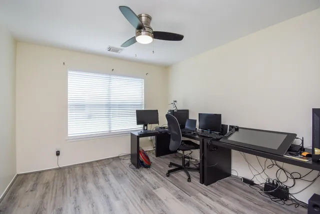a view of a workspace with furniture and a window