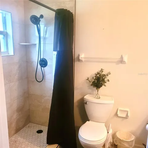 a bathroom with a toilet and a shower