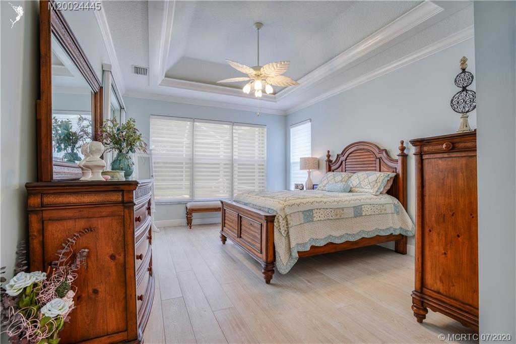 2198 Southwest Mainsail Terrace Stuart, FL 34997 - Photo 14 of 68 a bedroom with a bed and a chandelier
