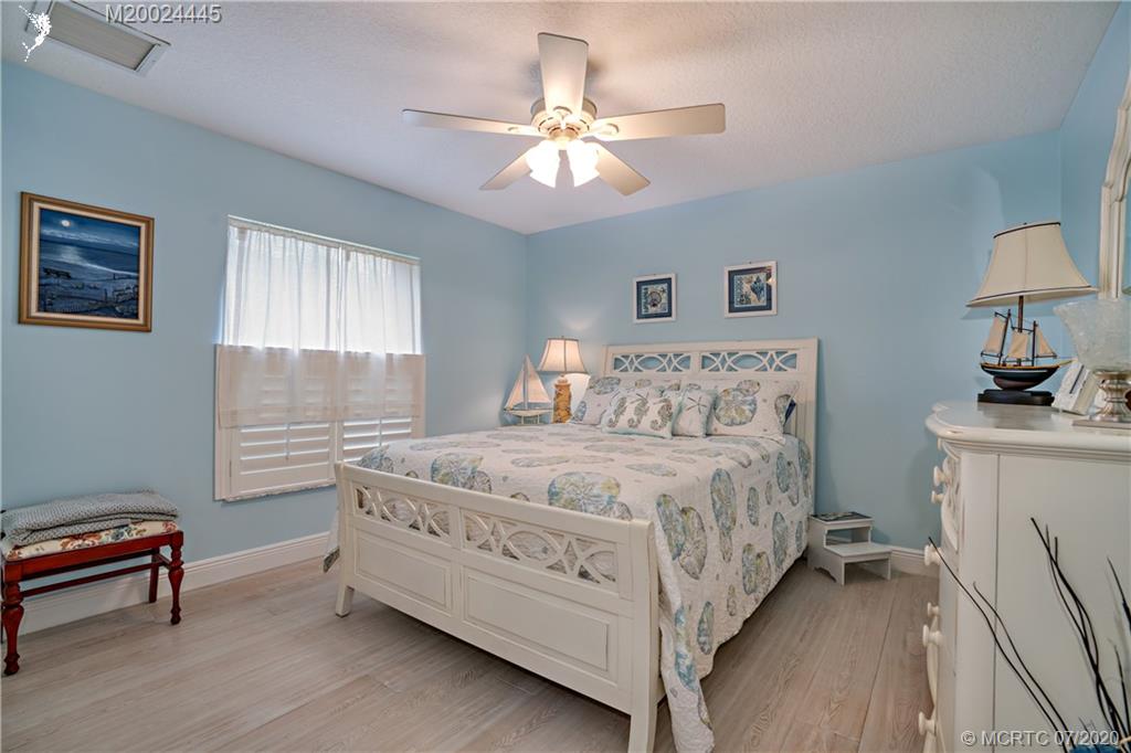 2198 Southwest Mainsail Terrace Stuart, FL 34997 - Photo 16 of 68 a bedroom with a bed and a chandelier