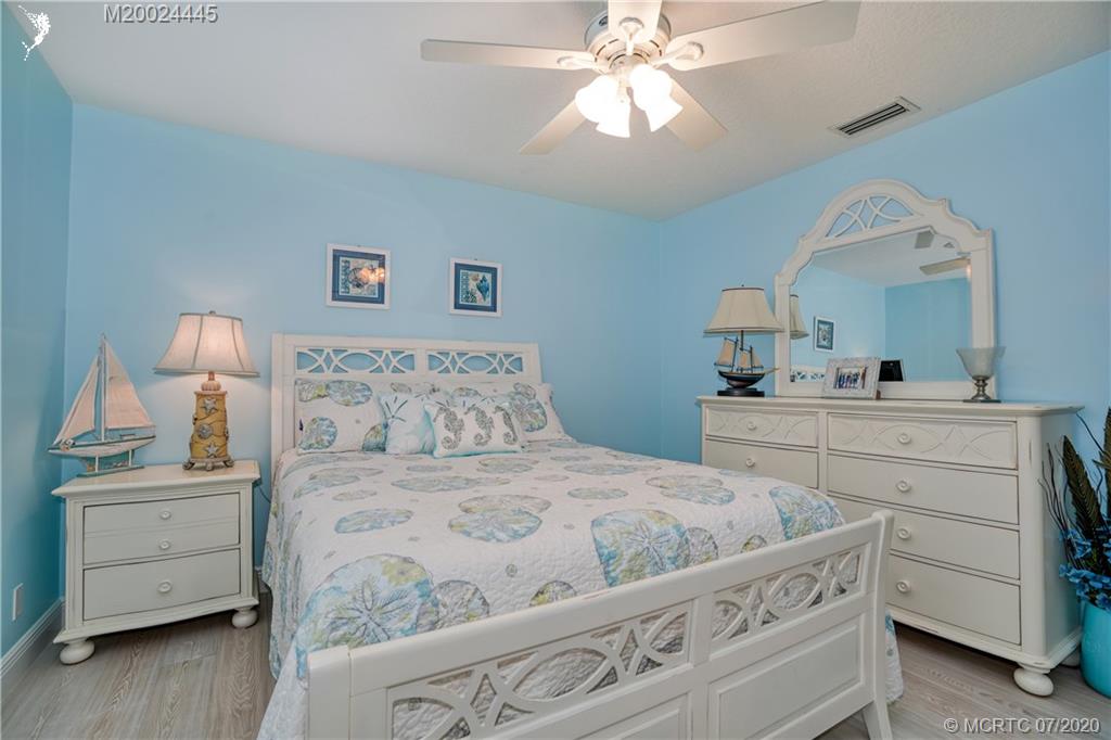 2198 Southwest Mainsail Terrace Stuart, FL 34997 - Photo 17 of 68 a bedroom with a bed and a chandelier