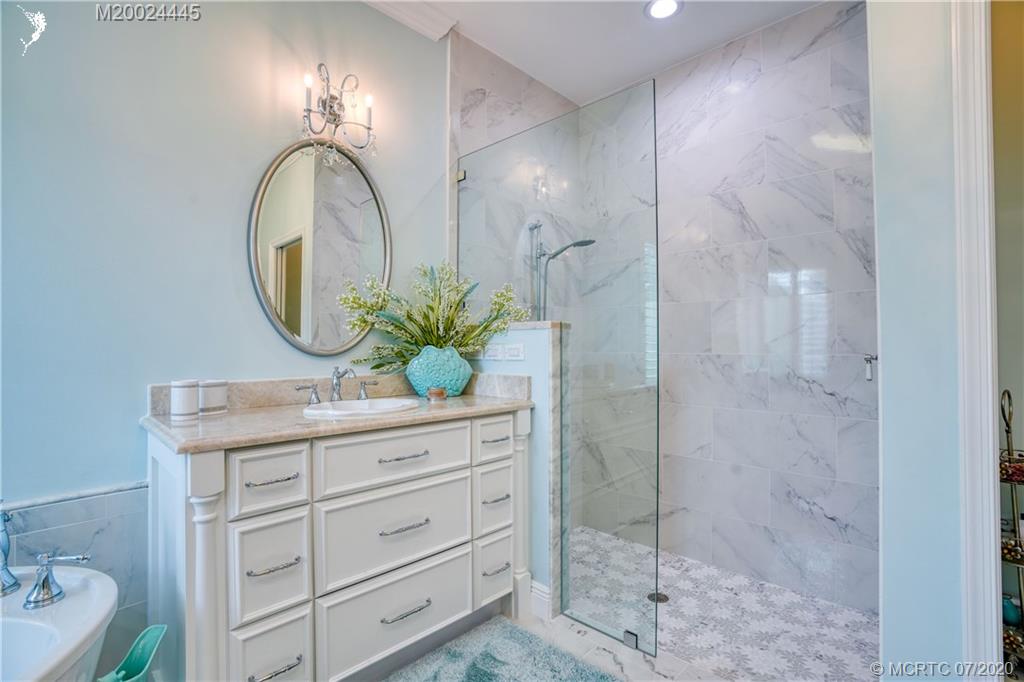 2198 Southwest Mainsail Terrace Stuart, FL 34997 - Photo 23 of 68 a bathroom with a granite countertop sink a mirror and shower