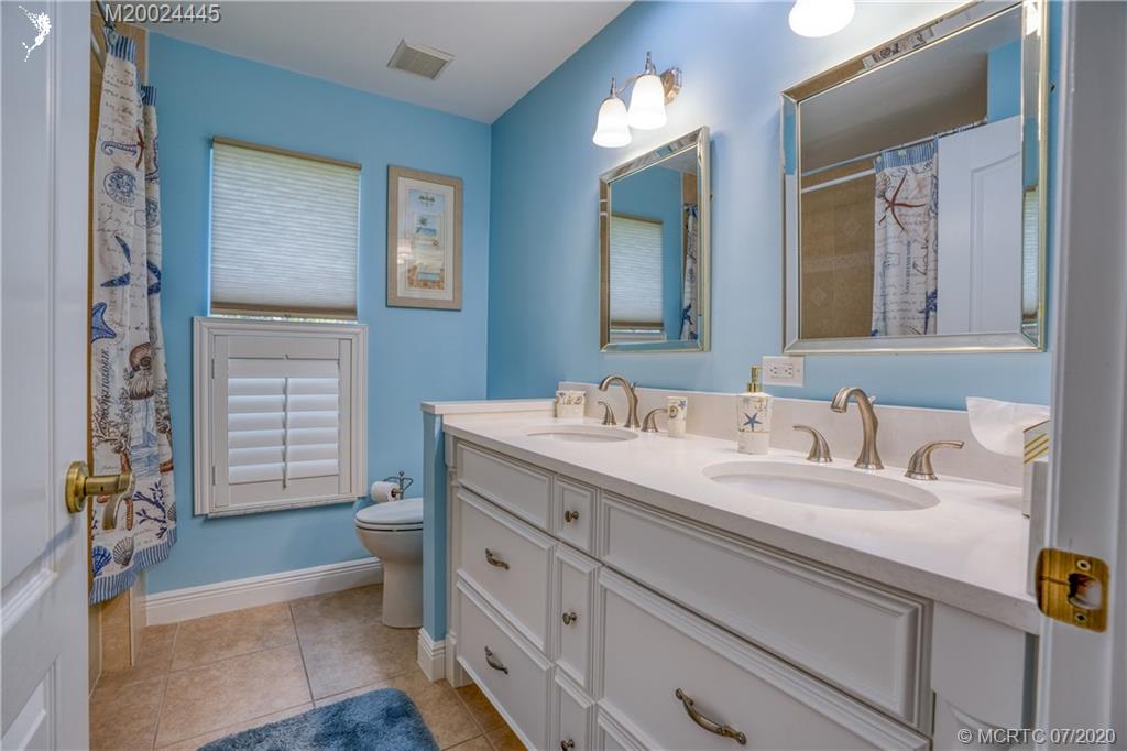 2198 Southwest Mainsail Terrace Stuart, FL 34997 - Photo 27 of 68 a bathroom with a sink a toilet and a mirror