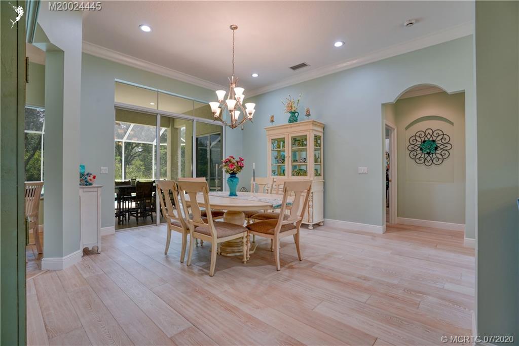 2198 Southwest Mainsail Terrace Stuart, FL 34997 - Photo 55 of 68 a dining room with furniture a chandelier and wooden floor