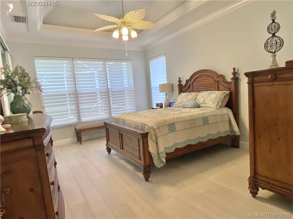2198 Southwest Mainsail Terrace Stuart, FL 34997 - Photo 65 of 68 a bedroom with a bed and a chandelier