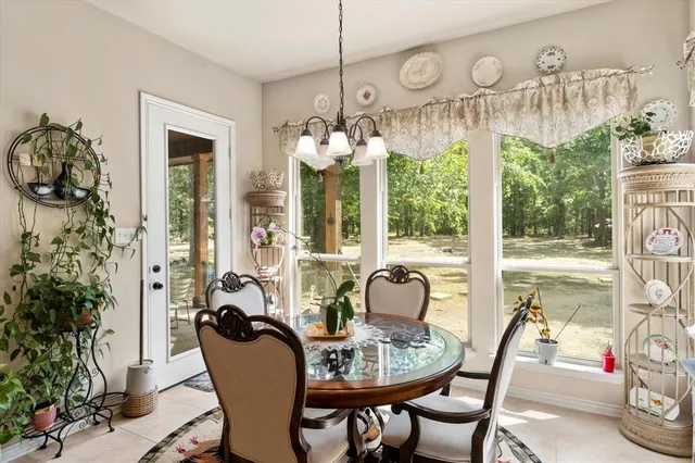 a dining room with furniture large windows and a chandelier