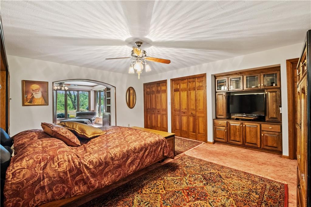 46 Cheslock Road Canonsburg, PA 15317 - Photo 14 of 24 a bedroom with a large bed a flat tv screen and a chandelier