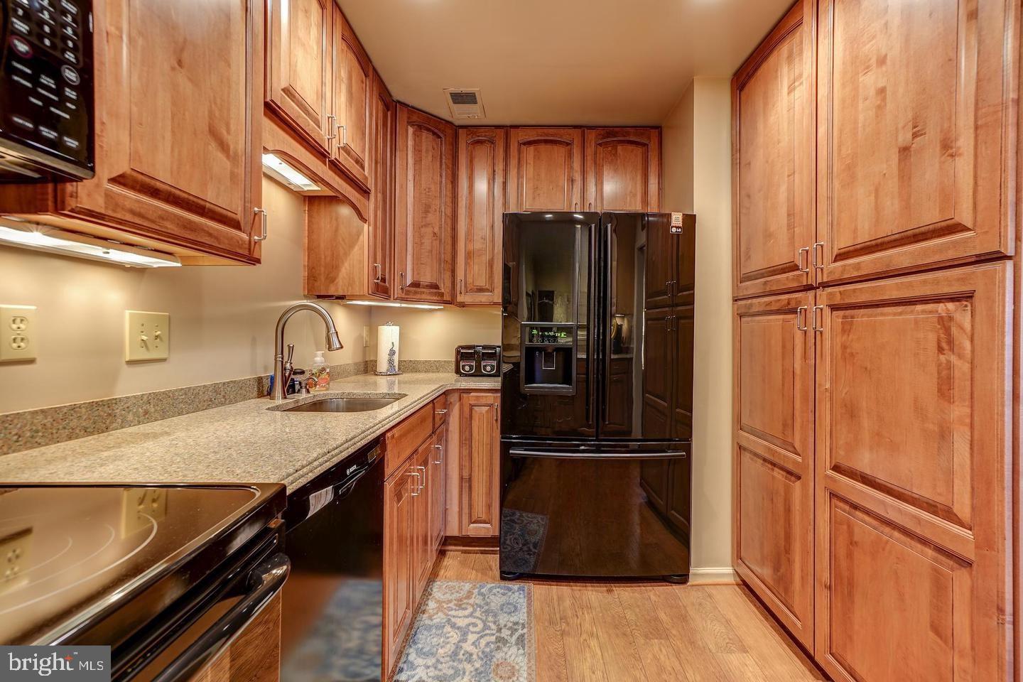 10706 Kings Riding Way, Unit 20118 Rockville, MD 20852 - Photo 7 of 24 a kitchen with granite countertop stainless steel appliances a refrigerator and cabinets
