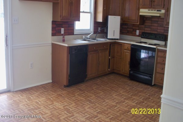 1109 Beechnut Road Effort, PA 18330 - Photo 3 of 8 a kitchen with stainless steel appliances granite countertop a sink and a stove