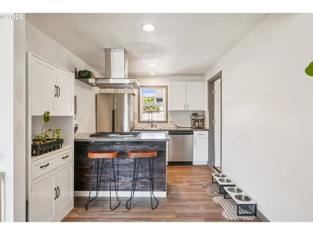 a kitchen with stainless steel appliances kitchen island granite countertop a stove a sink and a refrigerator