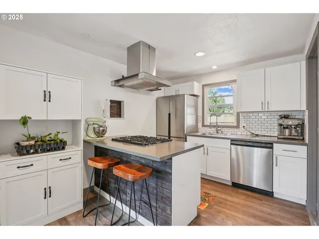 a kitchen with stainless steel appliances a sink stove and cabinets