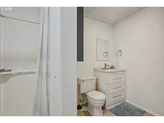 a bathroom with a toilet a sink and mirror