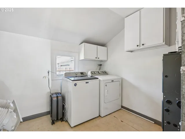 a utility room with cabinets washer and dryer