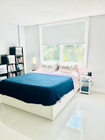 a bed sitting in a bedroom next to a window