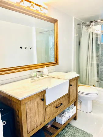 a bathroom with a sink a toilet and shower
