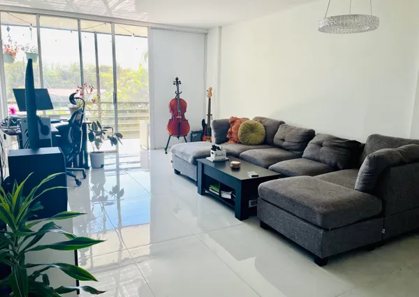 a living room with furniture and floor to ceiling windows