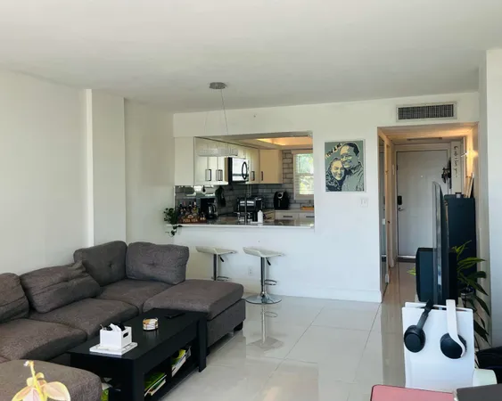 a living room with furniture and a view of kitchen