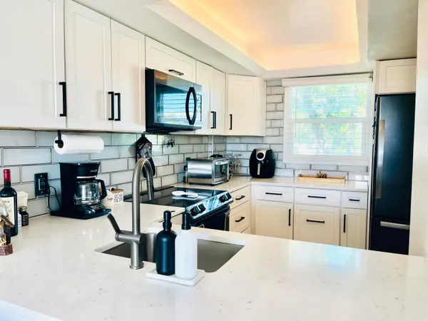 a kitchen with cabinets appliances a sink and a window