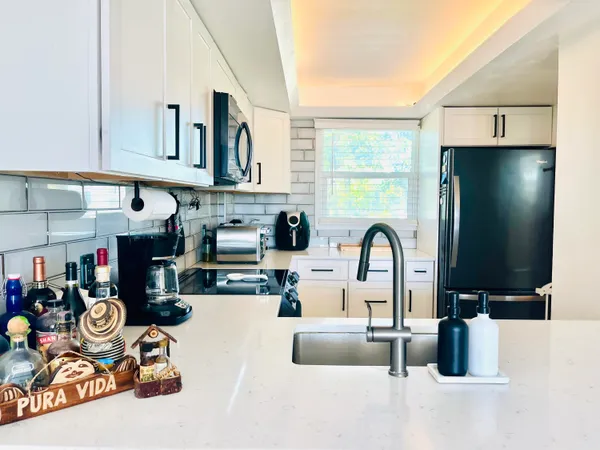 a kitchen with a refrigerator and a stove top oven