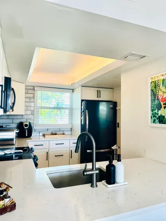 a view of a kitchen with stainless steel appliances a sink and a stove