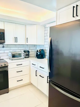 a kitchen with white cabinets and white appliances