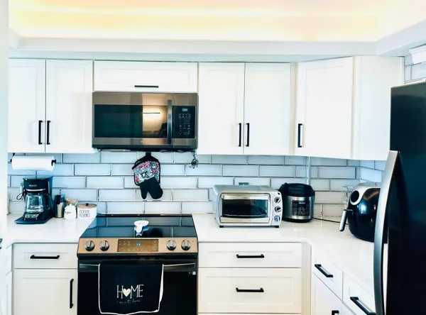 a kitchen with stainless steel appliances a stove and a microwave
