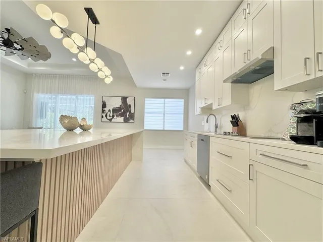 a kitchen with stainless steel appliances granite countertop a sink a stove top oven a counter space and cabinets