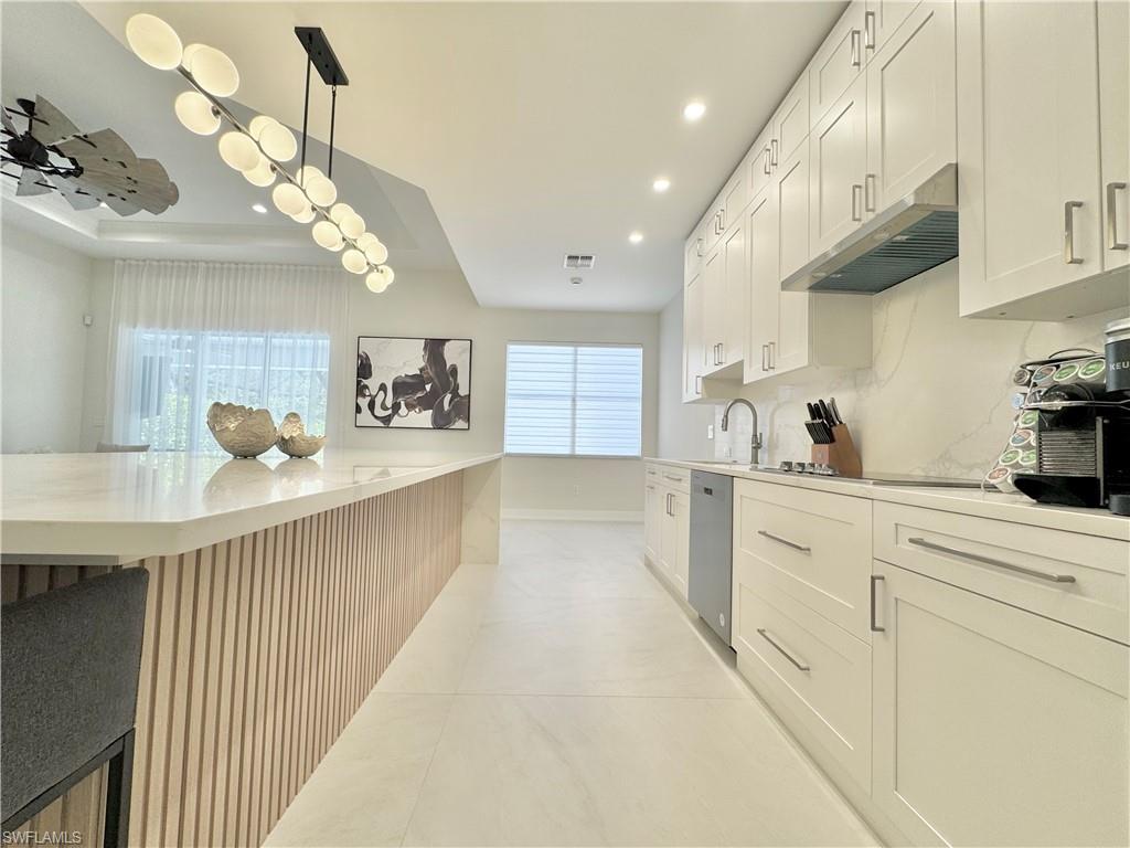 12667 Biscayne Court Naples, FL 34105 - Photo 17 of 41 a kitchen with stainless steel appliances granite countertop a sink a stove top oven a counter space and cabinets