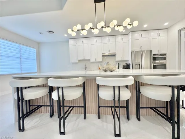 a kitchen with kitchen island a dining table and chairs