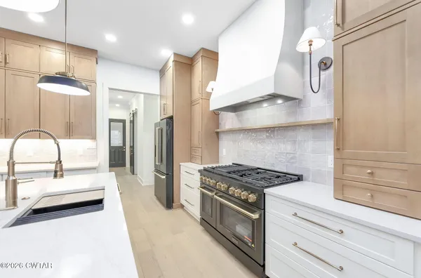 a kitchen with stainless steel appliances granite countertop a stove and a refrigerator