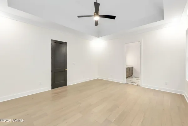 an empty room with fan and windows