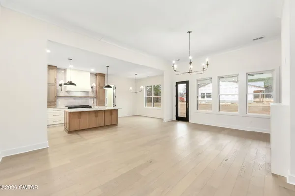a view of a kitchen with refrigerator and wooden floor