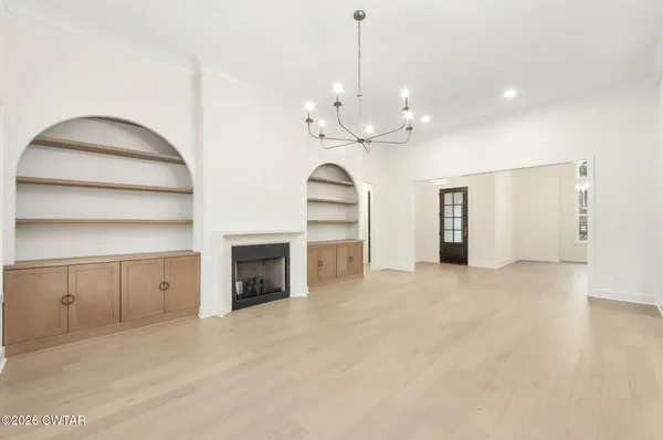 a view of an empty room with a fireplace and a cabinet