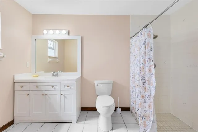 a spacious bathroom with a granite countertop shower a toilet and a sink