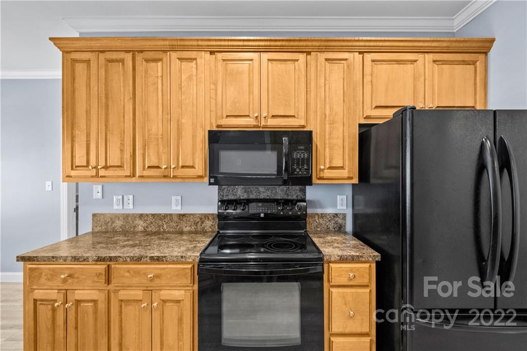 402 Ellicott Lane Locust, NC 28097 - Photo 11 of 41 a kitchen with a stove a sink and a refrigerator