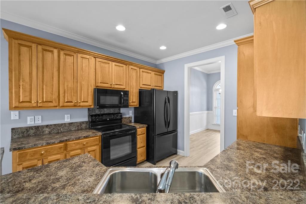402 Ellicott Lane Locust, NC 28097 - Photo 10 of 41 a kitchen with granite countertop a refrigerator and a sink