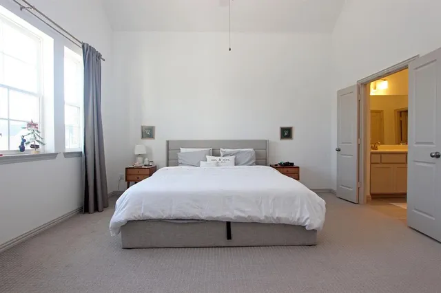 a bedroom with a bed tv and a window