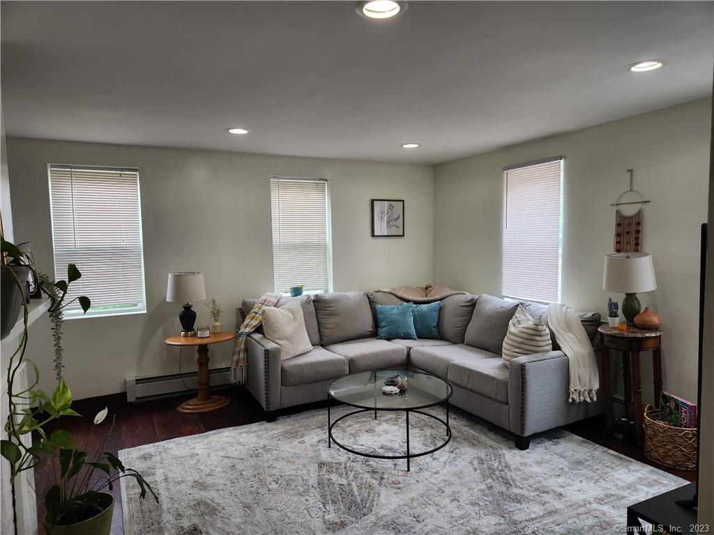 2 Lyons Road, Unit 4 Stafford, CT 06076 - Photo 1 of 1 a living room with furniture and wooden floor