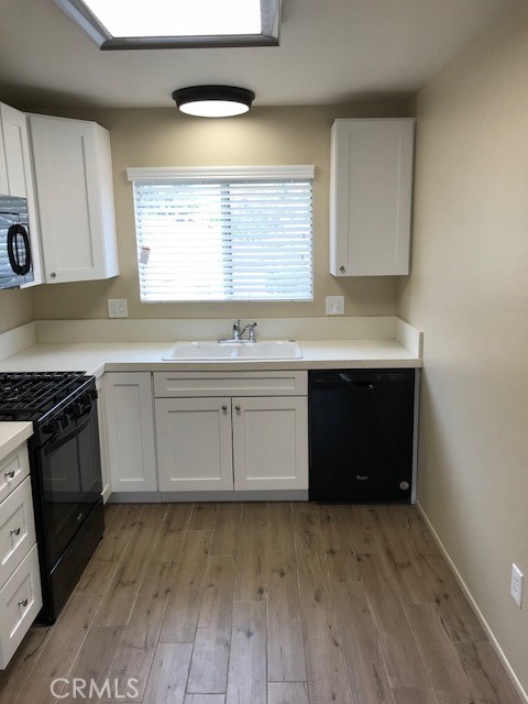 4261 Cedar Drive, Unit 10 San Bernardino, CA 92407 - Photo 7 of 15 a kitchen with a sink stove and cabinets