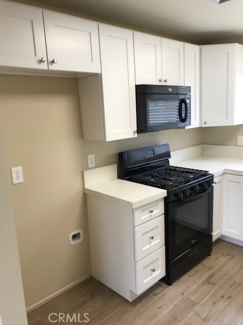 4261 Cedar Drive, Unit 10 San Bernardino, CA 92407 - Photo 9 of 15 a kitchen with granite countertop white cabinets and white appliances