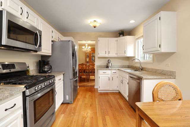 a kitchen with stainless steel appliances granite countertop a stove a sink and a microwave