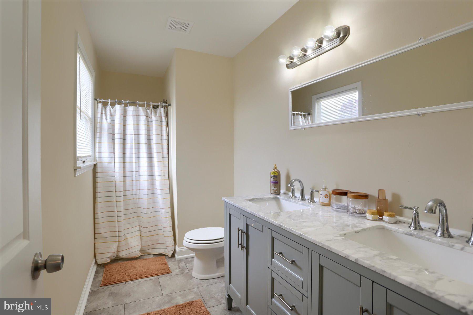3704 Reichert Road Harrisburg, PA 17110 - Photo 23 of 44 a bathroom with a granite countertop sink a toilet and a mirror
