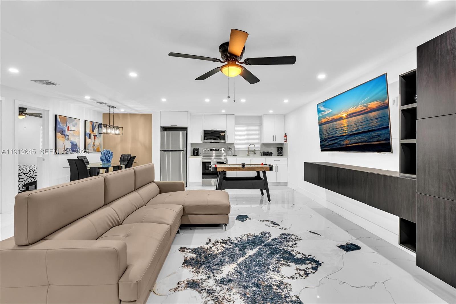a living room with furniture kitchen view and a window