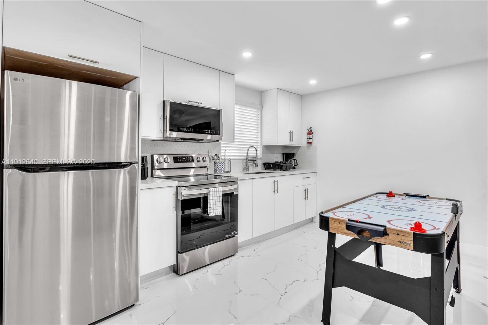 923 Northwest 110th Street, Unit A Miami, FL 33168 - Photo 11 of 21 a kitchen with white cabinets stainless steel appliances and sink