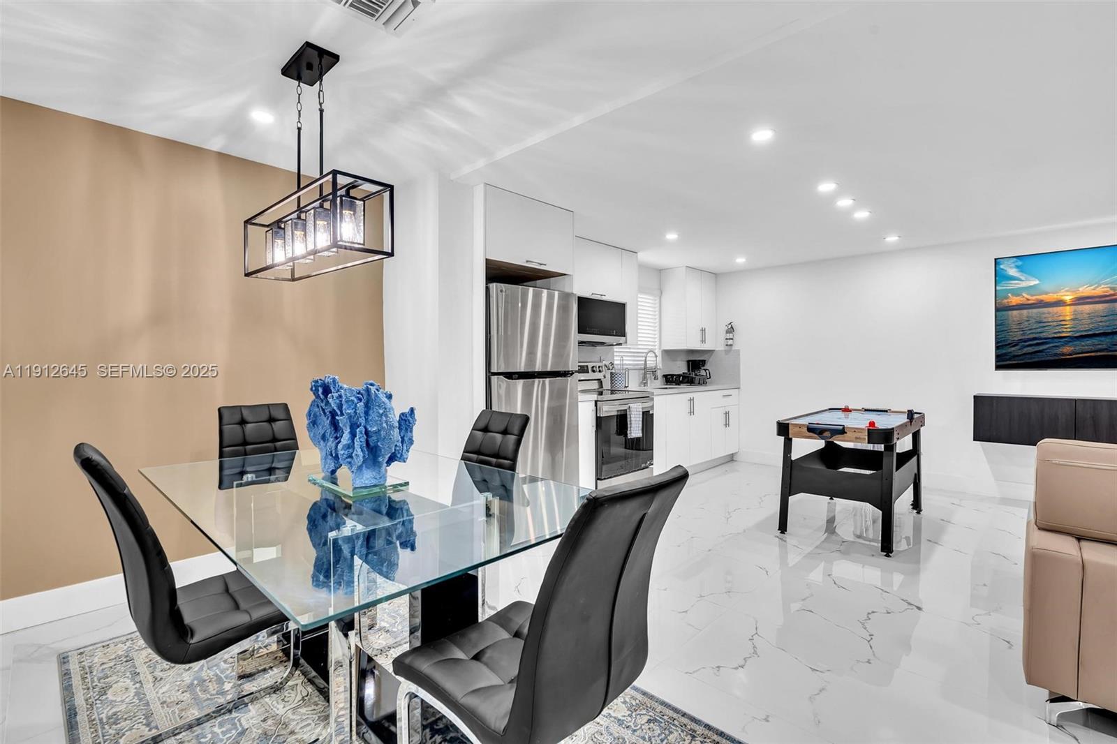 923 Northwest 110th Street, Unit A Miami, FL 33168 - Photo 15 of 21 a dining room with furniture a chandelier and wooden floor