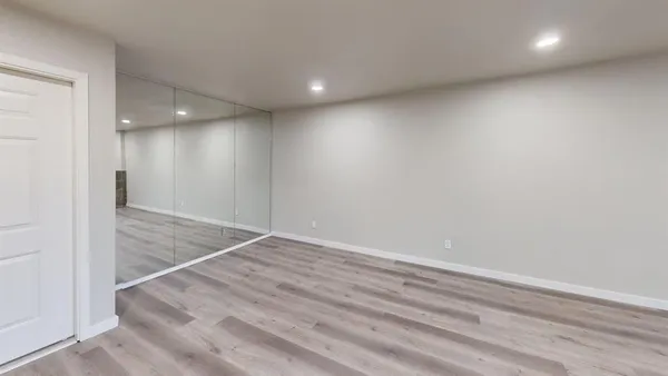 an empty room with a window and a fan