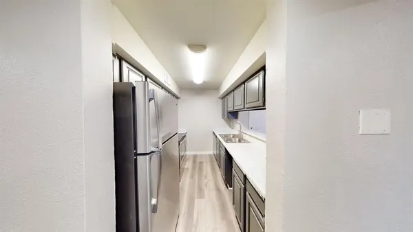 a view of staircase with lots of frames on wall and wooden floor